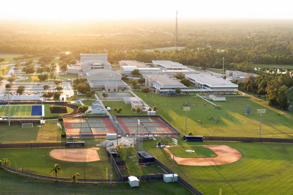 Aerial view of colleges in Karnataka with sports grounds at sunrise
